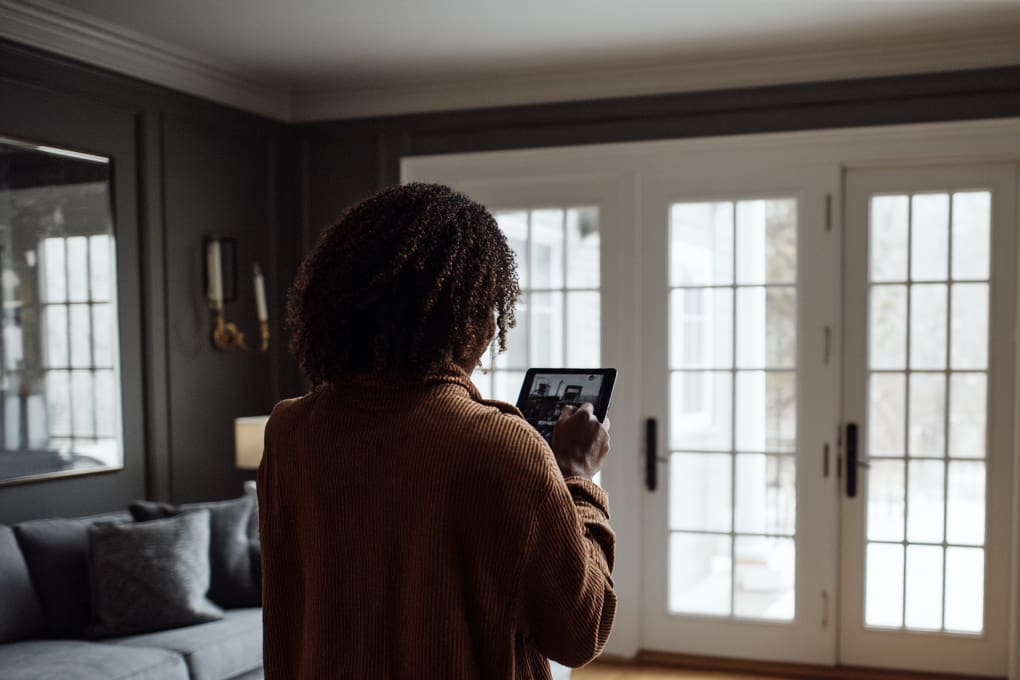 Woman in a house holding a tablet